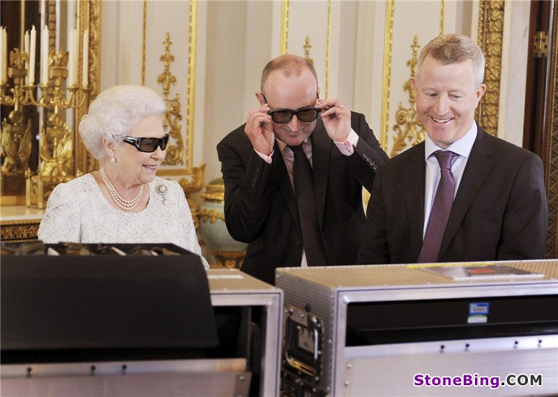 Britain's Queen Elizabeth (L) watches a preview of her Christmas message with a pair of 3D glasses, studded with Swarovski crystals in the form of a "Q", with producer John McAndrew and director John Bennett (R), at Buckingham Palace in central London in a photo released Dec 24, 2012. The Christmas message to the Commonwealth is to be broadcast in 3D for the first time. [Photo/Agencies]